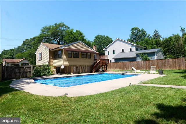 a front view of house with yard and trees in the background