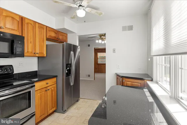 a kitchen with stainless steel appliances granite countertop a refrigerator and a stove top oven