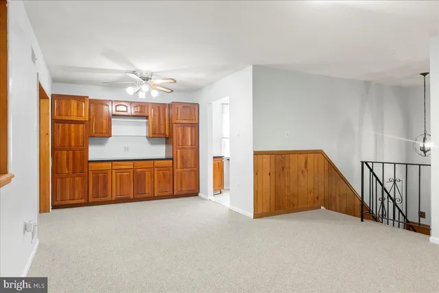 a view of an empty room with window and chandelier