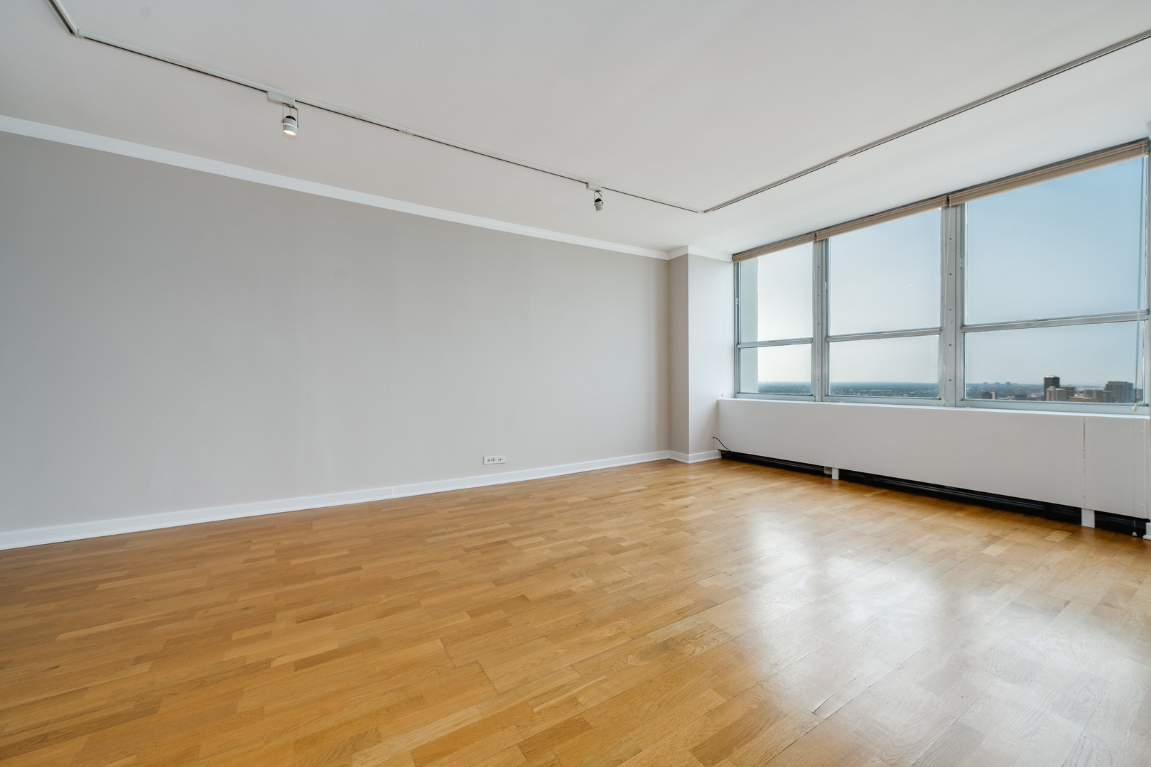 655 West Irving Park Road, Unit 5106 Chicago, IL 60613 - Photo 15 of 30 a view of an empty room with wooden floor and a window