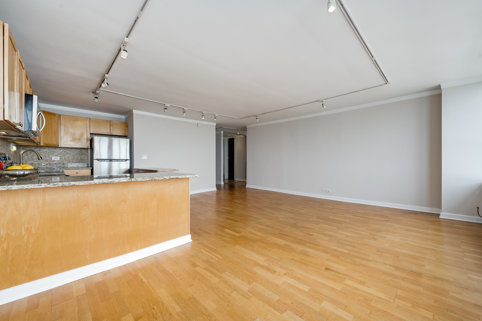 655 West Irving Park Road, Unit 5106 Chicago, IL 60613 - Photo 8 of 30 a view of kitchen and empty room with wooden floor