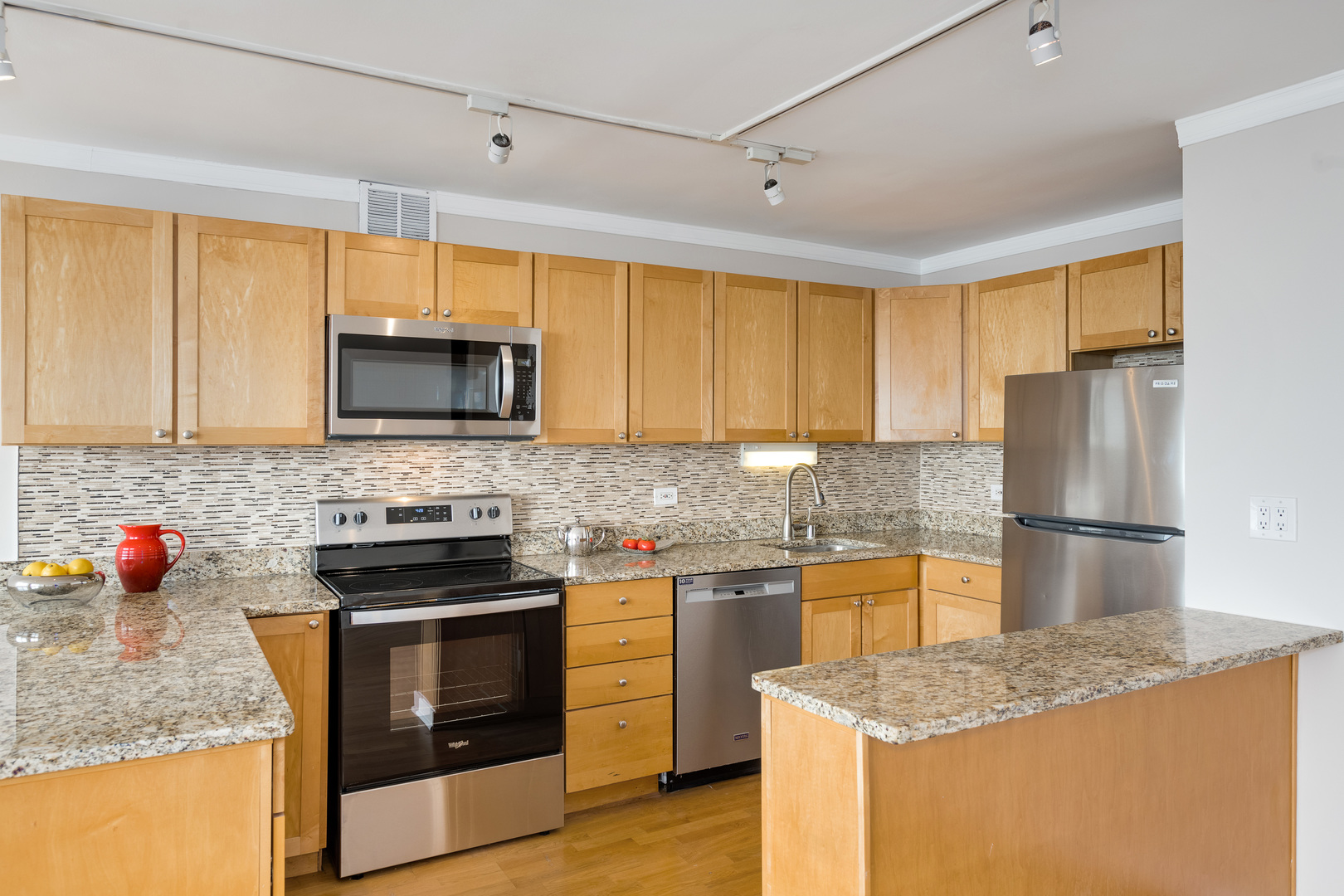 655 West Irving Park Road, Unit 5106 Chicago, IL 60613 - Photo 9 of 30 a kitchen with stainless steel appliances granite countertop a sink stove microwave and refrigerator