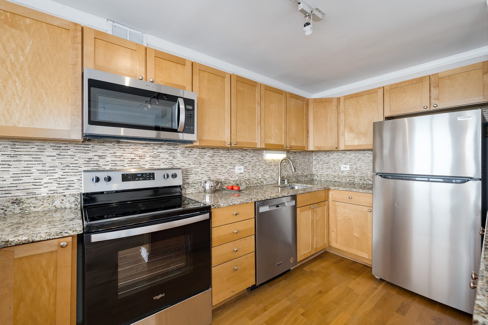 655 West Irving Park Road, Unit 5106 Chicago, IL 60613 - Photo 10 of 30 a kitchen with stainless steel appliances a stove microwave and refrigerator