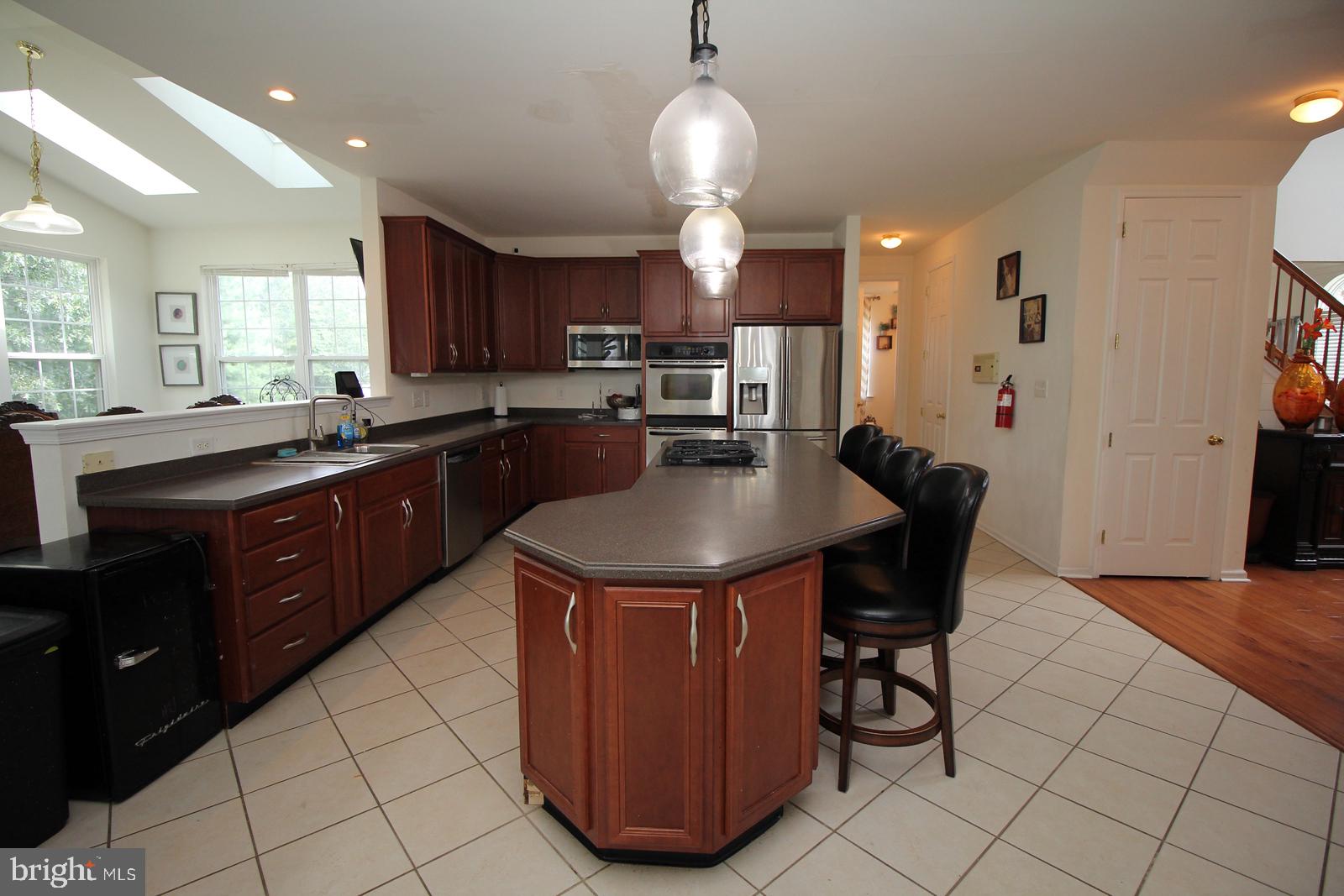 5 Kelly Drive Sicklerville, NJ 08081 - Photo 13 of 32 a kitchen with granite countertop a sink a stove a dining table and chairs