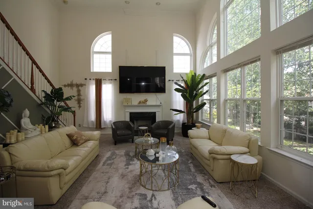 a living room with furniture a fireplace a flat screen tv and a large window