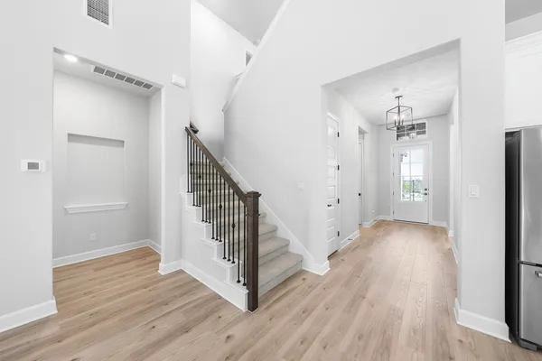a view of a hallway with wooden floor and stairs