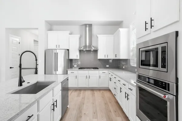 a kitchen with granite countertop a sink stainless steel appliances and cabinets