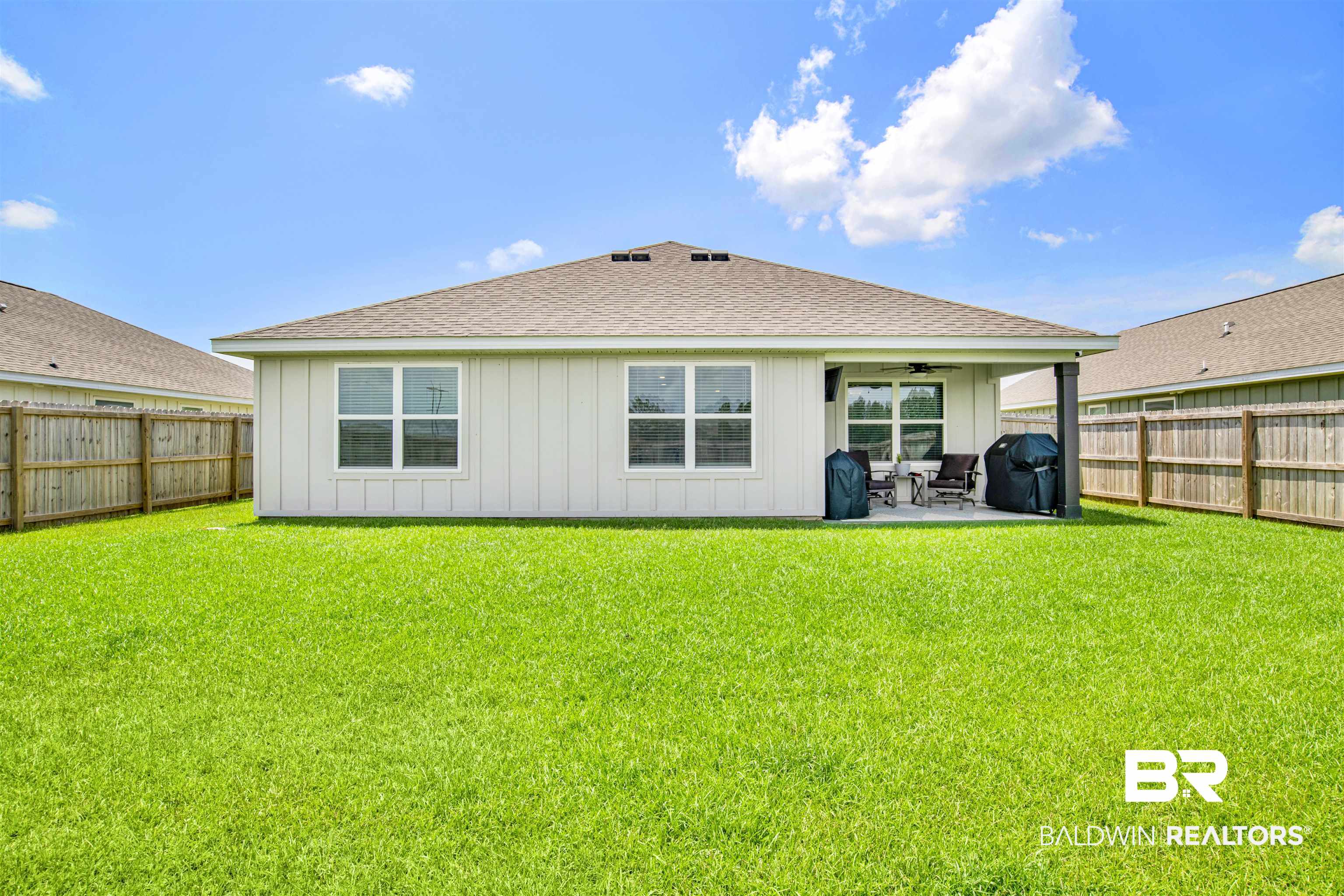14731 Forsythia Loop Silverhill, AL 36576 - Photo 23 of 25 Back of house featuring a patio area and a lawn