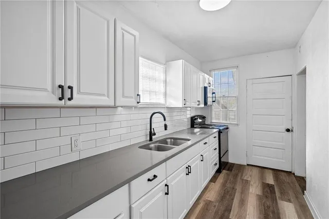 a kitchen with granite countertop white cabinets and sink