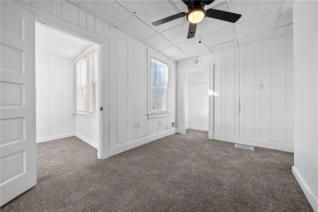 an empty room with chandelier fan