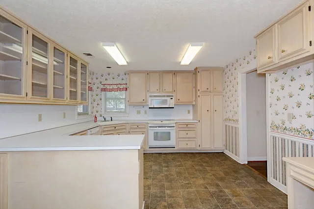 a kitchen with granite countertop a sink stove and cabinets