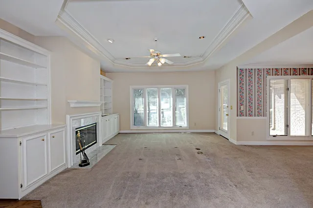 a view of livingroom with fireplace cabinet and windows