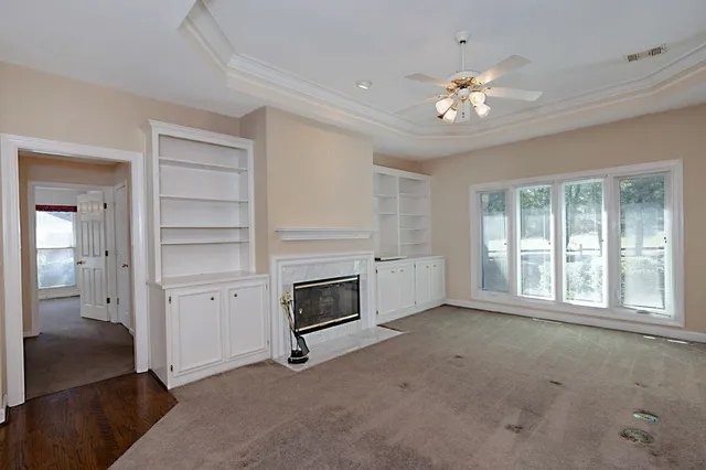 a view of an empty room with a fireplace and chandelier