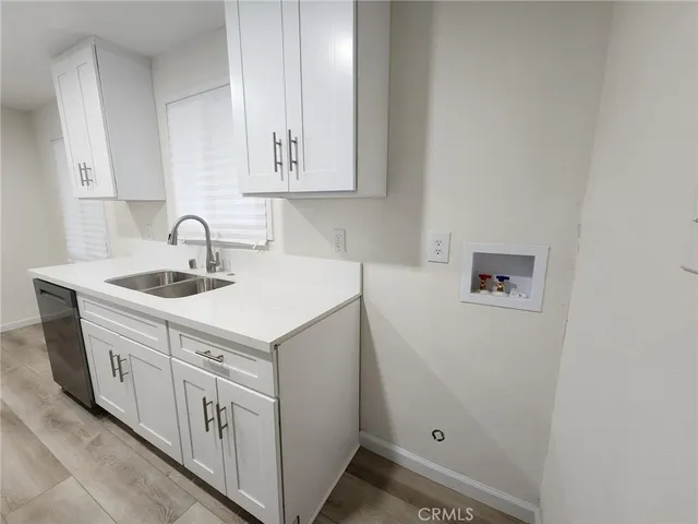 a kitchen with white cabinets and sink