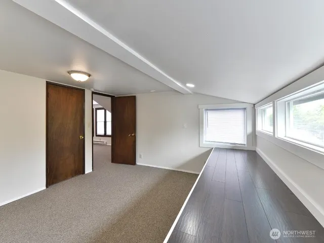 a view of a big room with wooden floor and windows