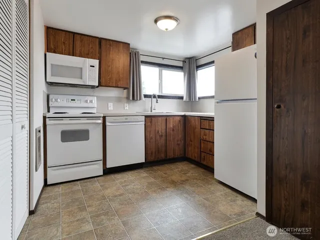 a kitchen with stainless steel appliances granite countertop a refrigerator sink and microwave