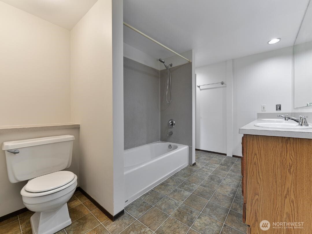 7519 Greenwood Avenue North, Unit 4 Seattle, WA 98103 - Photo 5 of 13 a bathroom with a sink a toilet and shower