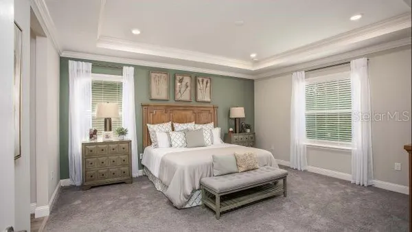 a bedroom with a bed a mirror and a window