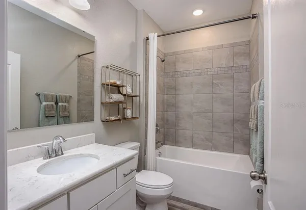 a bathroom with a granite countertop sink toilet and shower