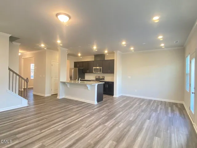 a open kitchen with kitchen island a sink dishwasher stove and oven with wooden floor