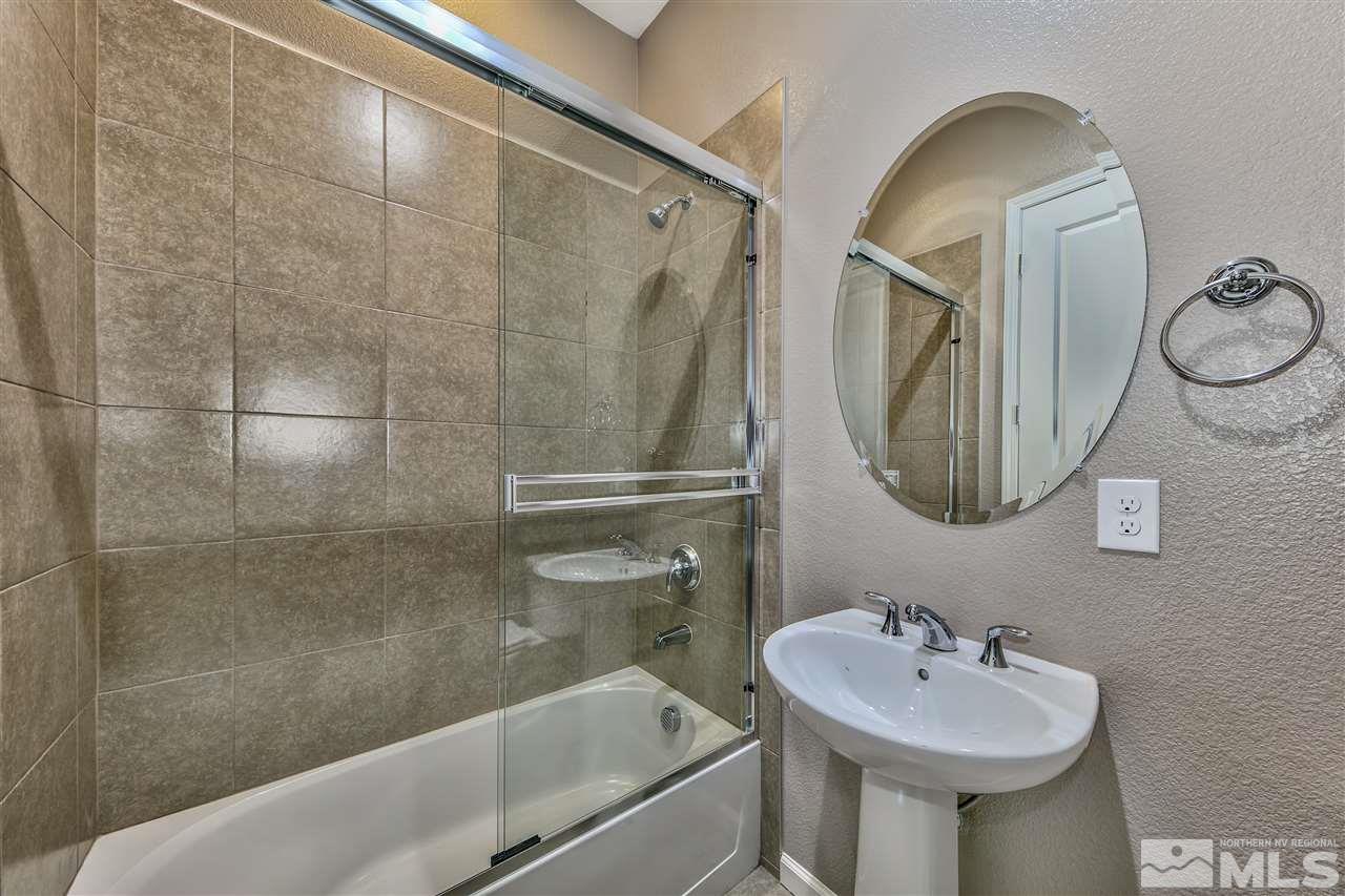 2109 Gregorgio Ln. Reno, NV 89521 - Photo 21 of 38 a bathroom with a sink a mirror and a shower