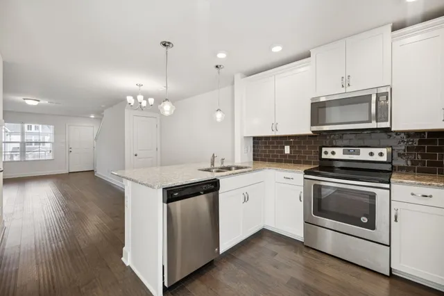a kitchen with stainless steel appliances granite countertop a stove a sink and a microwave