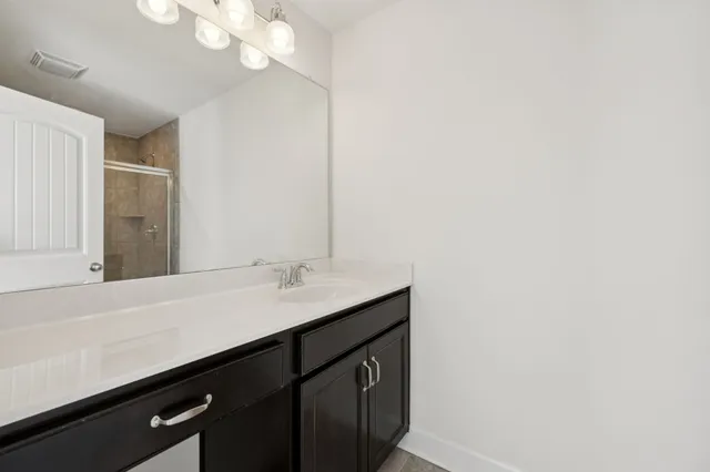 a bathroom with a sink a mirror and a light fixture