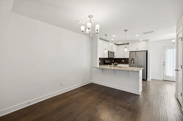 a view of kitchen with stove refrigerator and cabinets