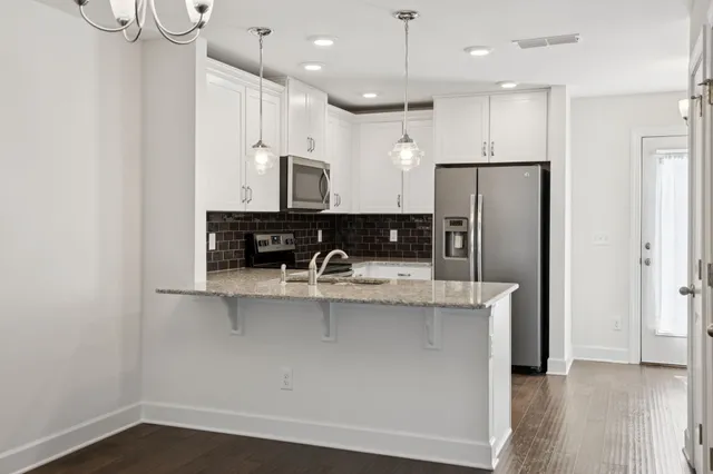 a view of a kitchen with stainless steel appliances granite countertop a refrigerator a sink and a stove