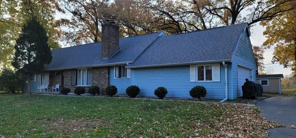 a brick house with a yard swing and a large tree