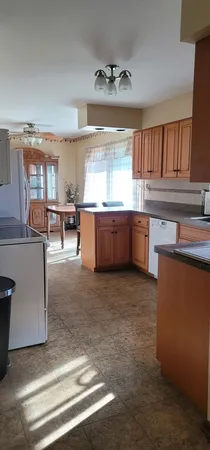 a large kitchen with kitchen island a sink stove and cabinets
