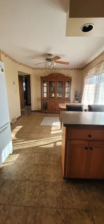 a view of kitchen with kitchen island a sink wooden floor and a large window