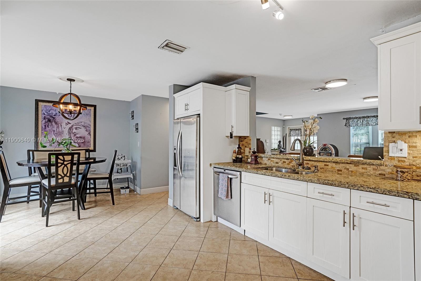 12221 Southwest 144th Terrace Miami, FL 33186 - Photo 12 of 42 a kitchen with stainless steel appliances granite countertop a refrigerator and a stove top oven