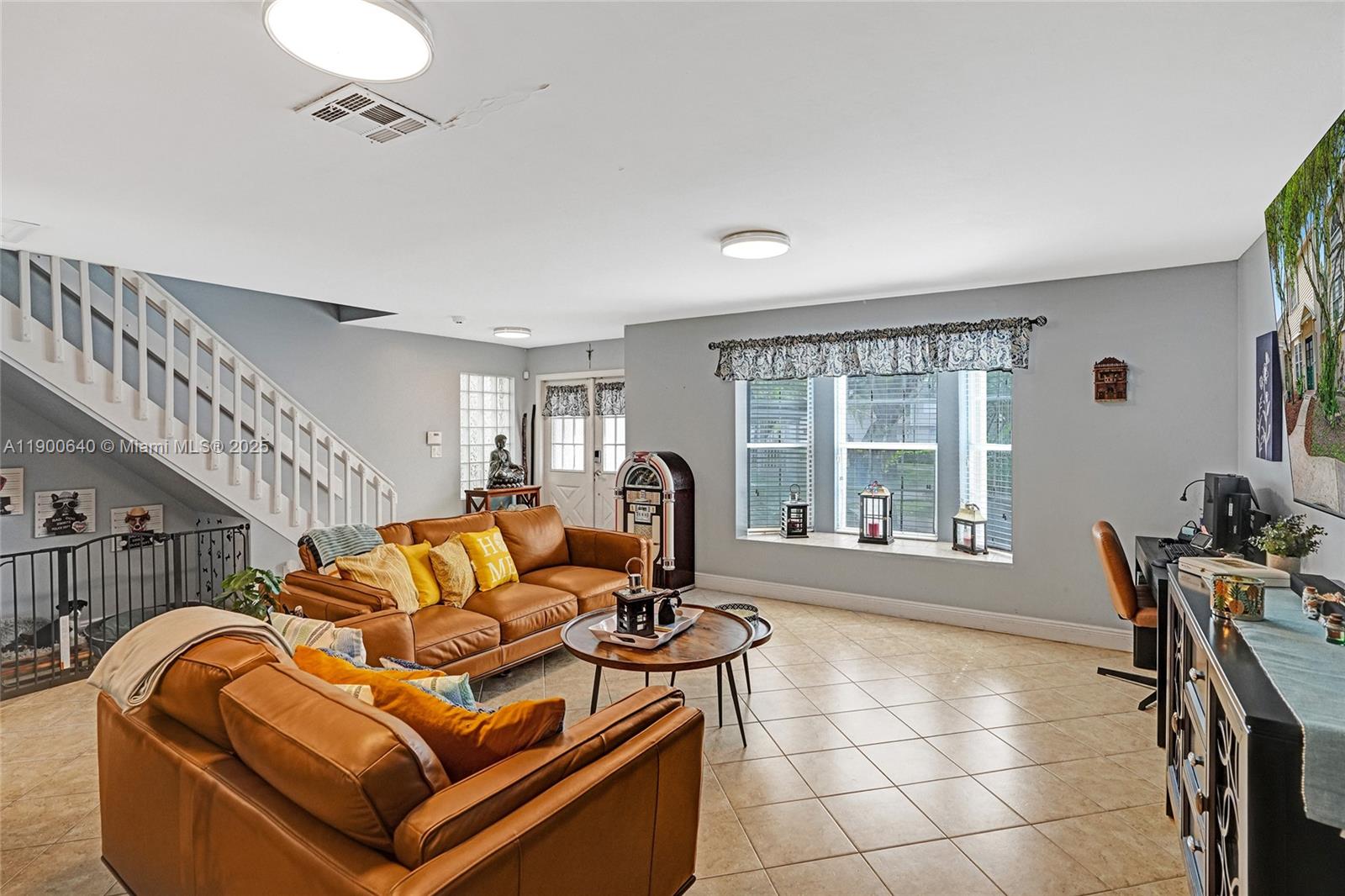 12221 Southwest 144th Terrace Miami, FL 33186 - Photo 3 of 42 a living room with furniture a flat screen tv and a large window