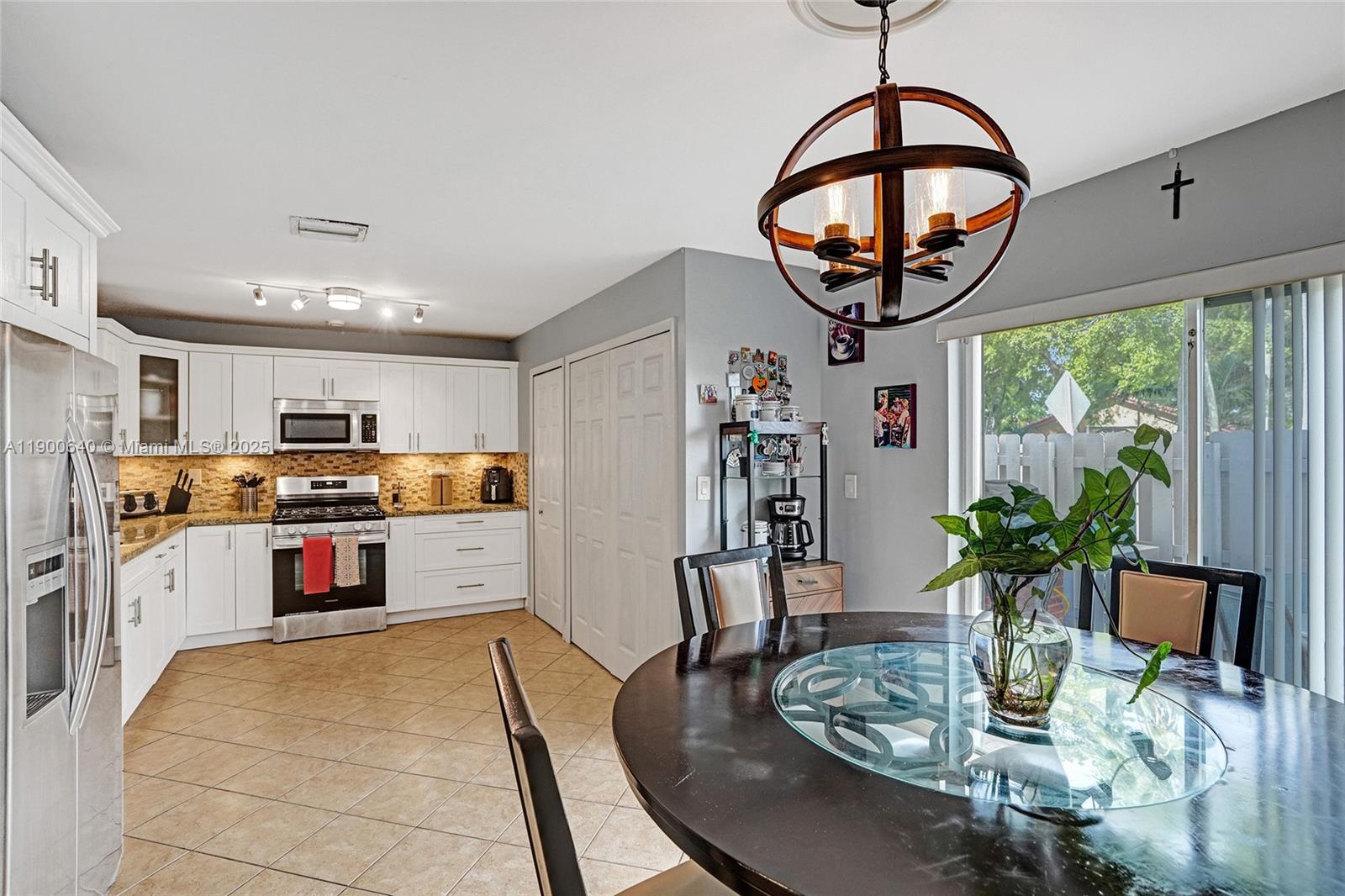 12221 Southwest 144th Terrace Miami, FL 33186 - Photo 9 of 42 a kitchen with stainless steel appliances granite countertop a stove and a dining table with kitchen view
