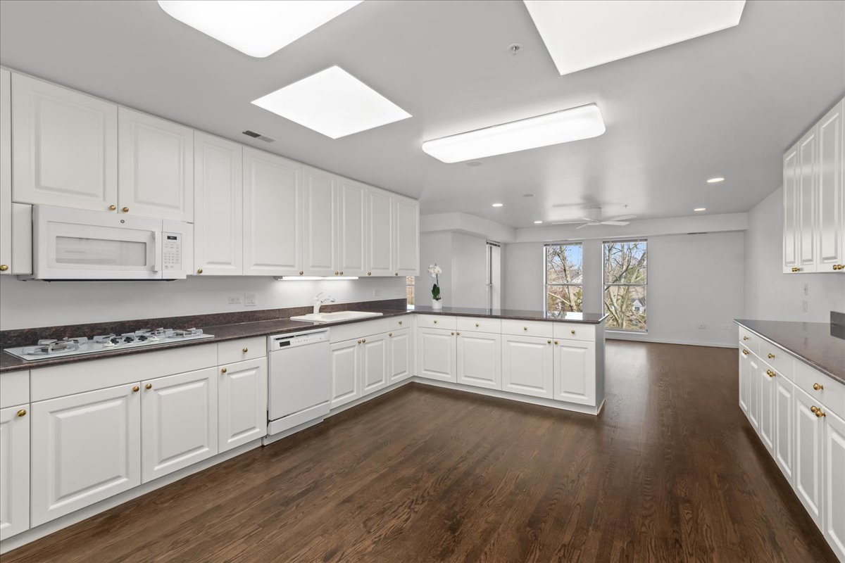 380 Green Bay Road, Unit 4D Winnetka, IL 60093 - Photo 12 of 25 a large kitchen with granite countertop a large counter top space a sink stainless steel appliances and cabinets