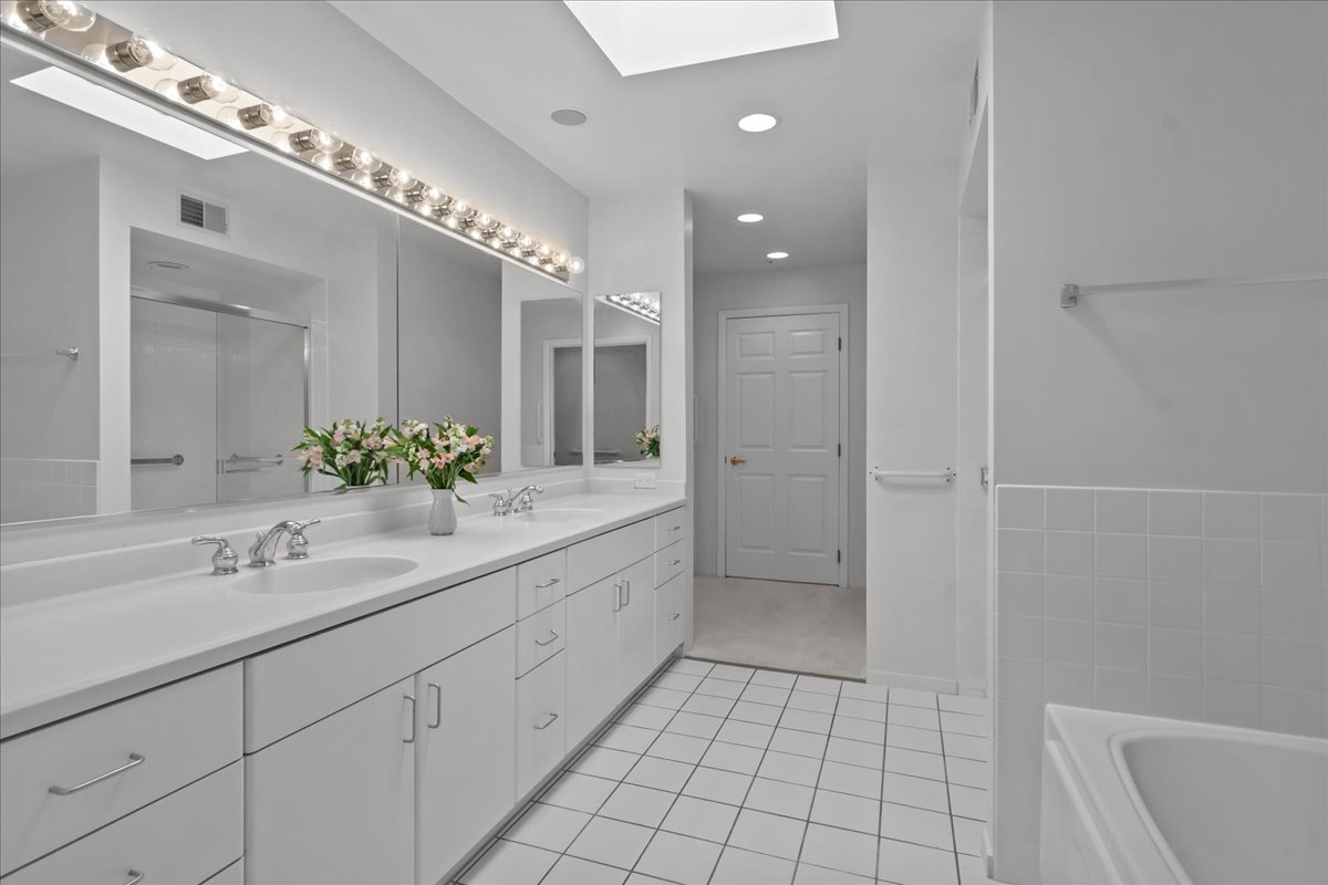 380 Green Bay Road, Unit 4D Winnetka, IL 60093 - Photo 18 of 25 a spacious bathroom with a shower sink and mirror