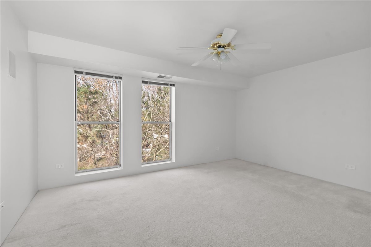 380 Green Bay Road, Unit 4D Winnetka, IL 60093 - Photo 22 of 25 an empty room with windows and chandelier fan