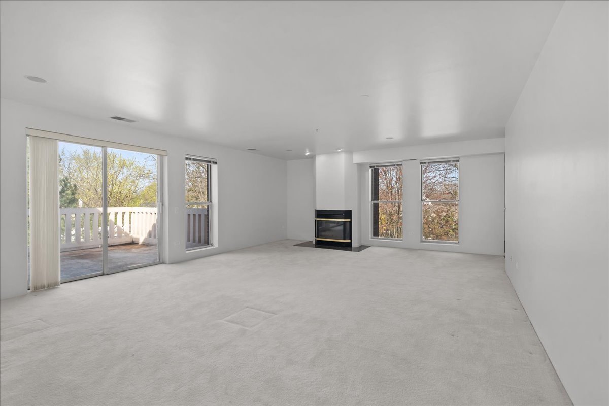 380 Green Bay Road, Unit 4D Winnetka, IL 60093 - Photo 7 of 25 a view of an empty room with a fireplace and a window