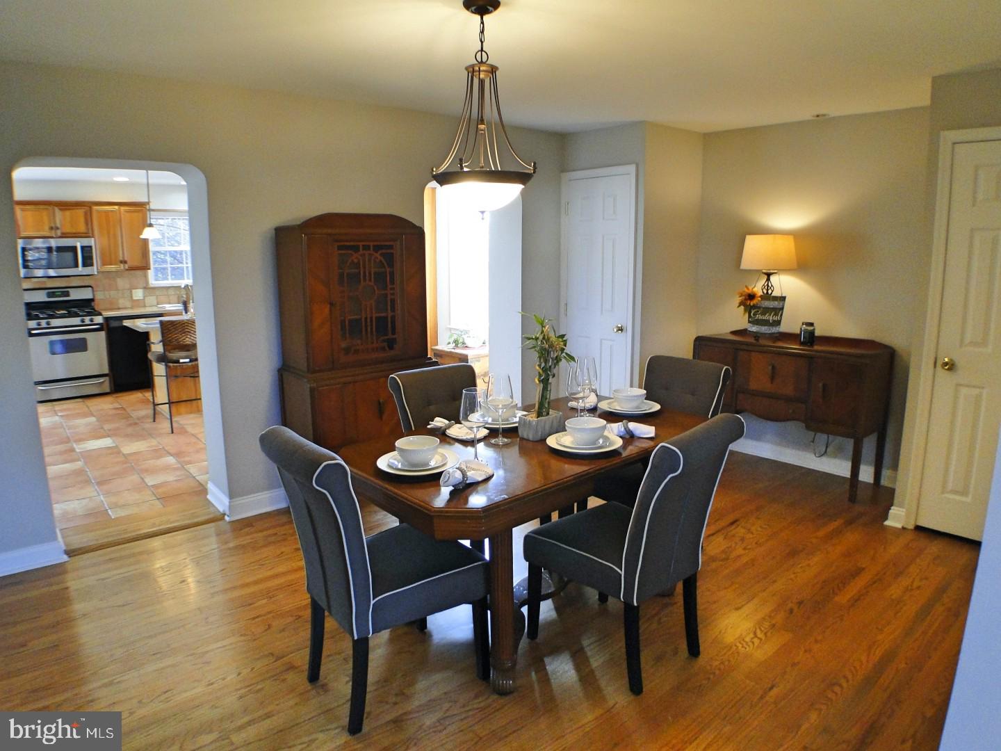 416 Valley View Road Springfield, PA 19064 - Photo 8 of 40 a dining room with furniture wooden floor a rug and a chandelier