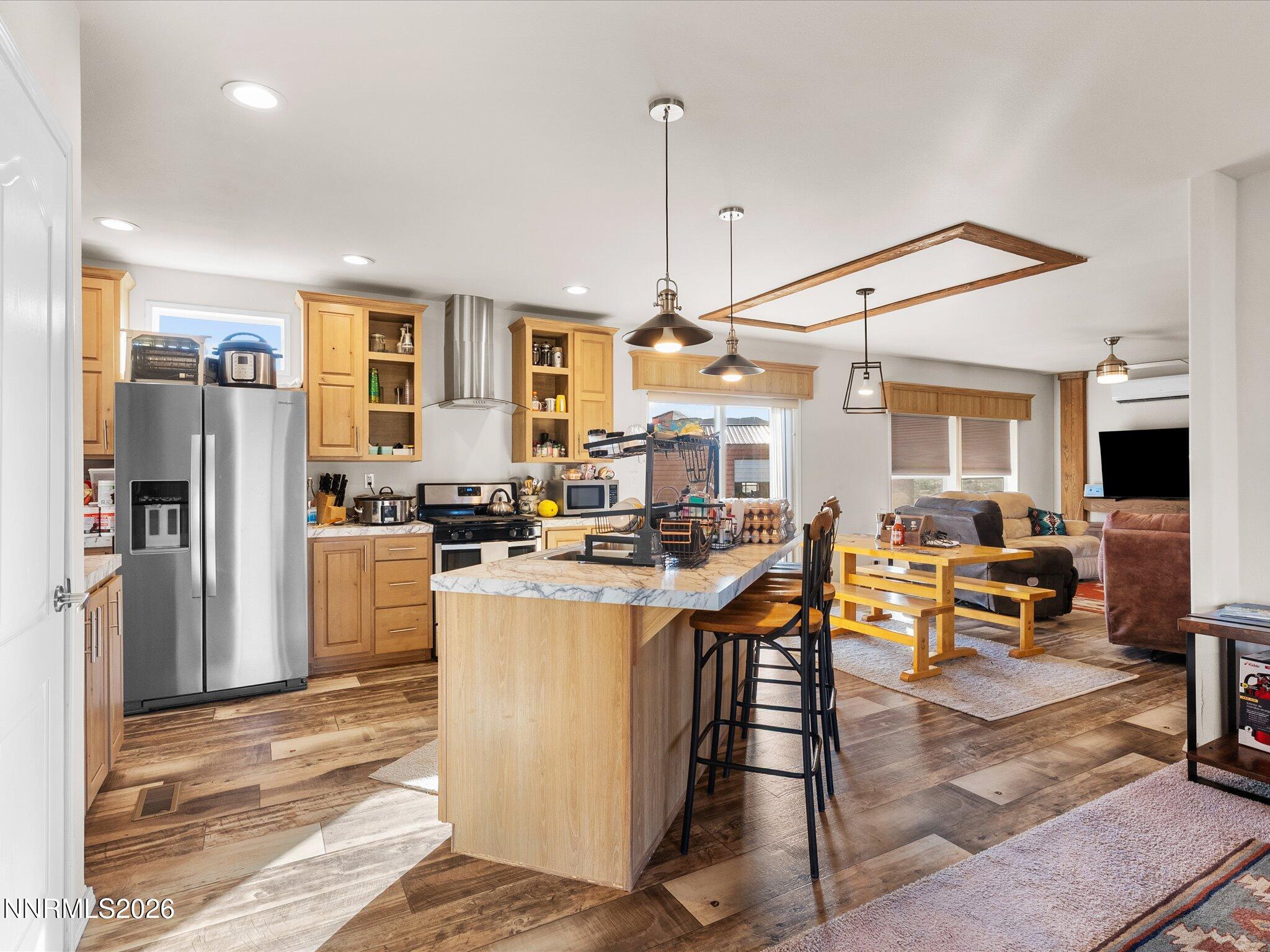 4555 Amy Road Reno, NV 89510 - Photo 12 of 74 a kitchen with stainless steel appliances kitchen island granite countertop a refrigerator a stove and a dining table with wooden floor