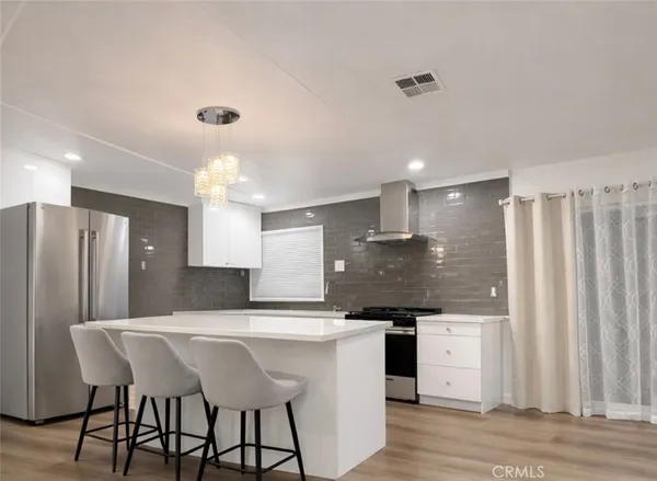 a kitchen with stainless steel appliances kitchen island a refrigerator and a sink