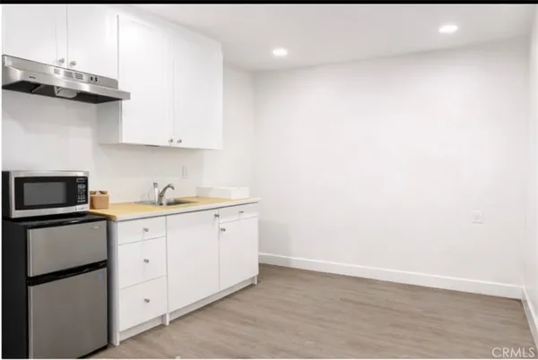 a kitchen with granite countertop white cabinets and a stainless steel appliances