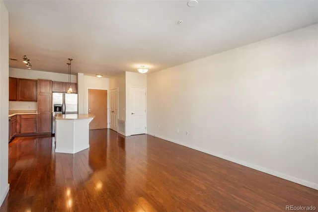 a view of kitchen with refrigerator and wooden floor