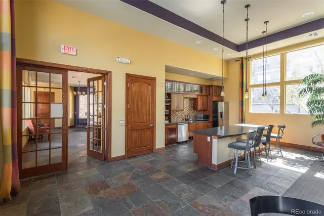 a dining room with stainless steel appliances granite countertop furniture and a chandelier