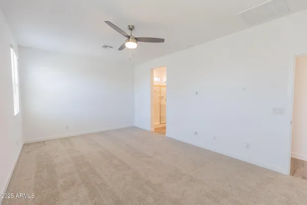 an empty room with a window and ceiling fan