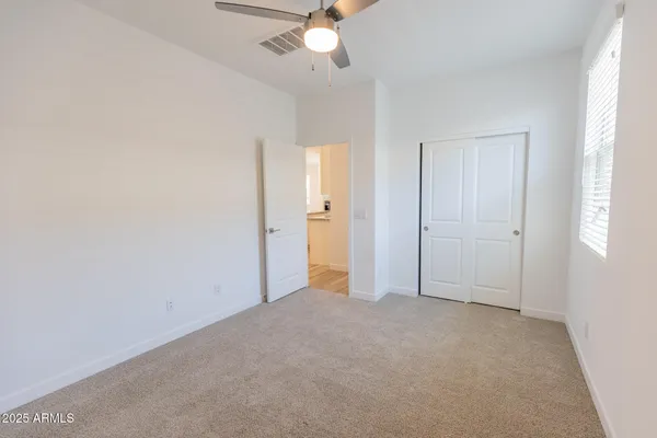 an empty room with a ceiling fan and a window