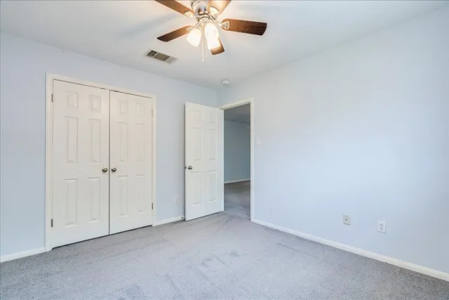 an empty room with a ceiling fan and a window