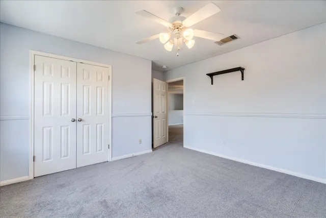 a view of an empty room with a ceiling fan