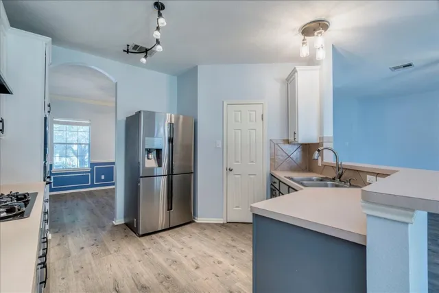 a kitchen with stainless steel appliances a refrigerator and a sink
